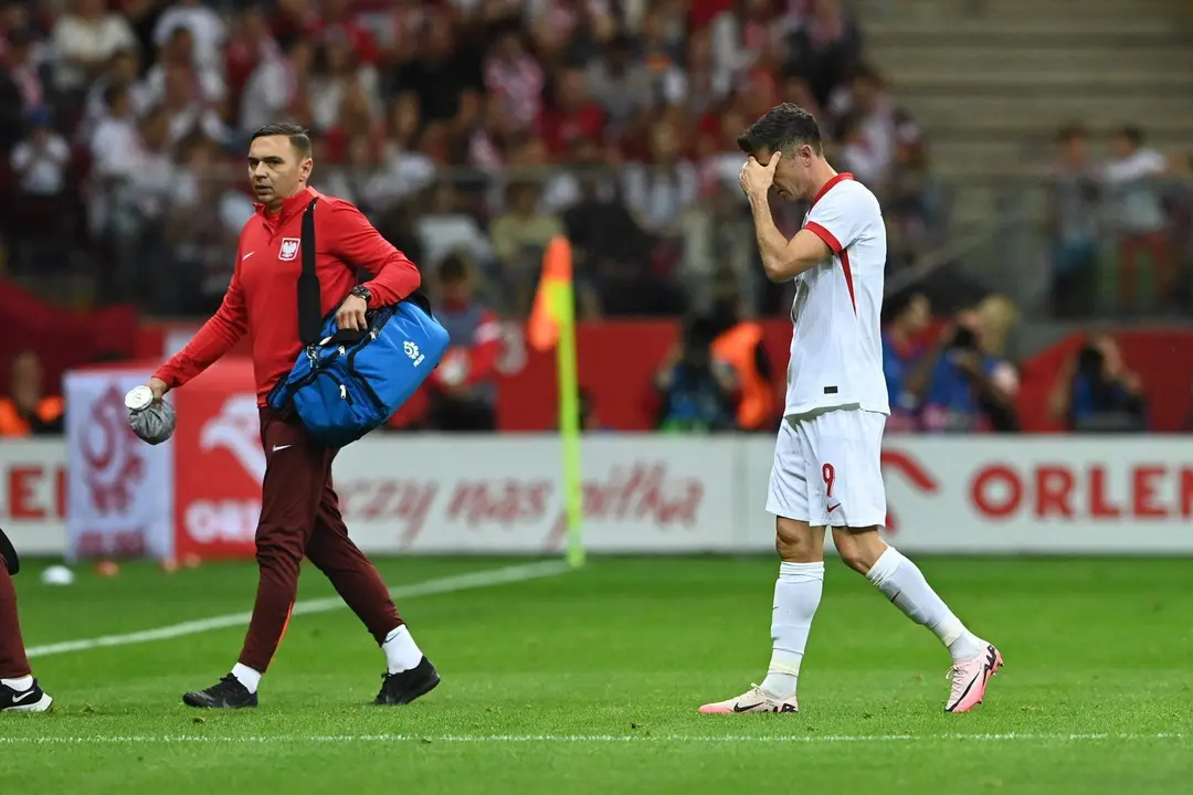 El delantero Robert Lewandowski (d) se retira lesionado durante el amistos que han jugado Polonia y Turqu&iacute;a en Varsovia,
