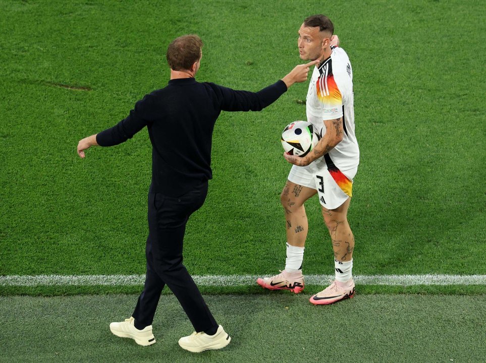 El seleccionador de Alemania Julian Nagelsmann (i) conversa David Raum durante el partido de la Eurocopa 2024 entre Alemania y Dinamarca, en Dortmund. EFE/EPA/GEORGI LICOVSKI