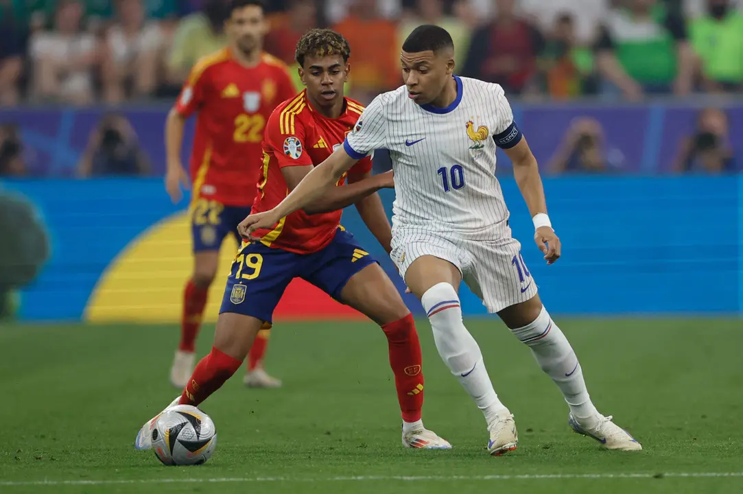 El delantero de la selecci&oacute;n espa&ntilde;ola Lamine Yamal (i) pelea un bal&oacute;n con Kylian Mbapp&eacute;, de Francia, durante el partido de semifinales de la Eurocopa de f&uacute;tbol que Espa&ntilde;a y Francia disputaron en M&uacute;nich. EFE/Alberto Est&eacute;vez