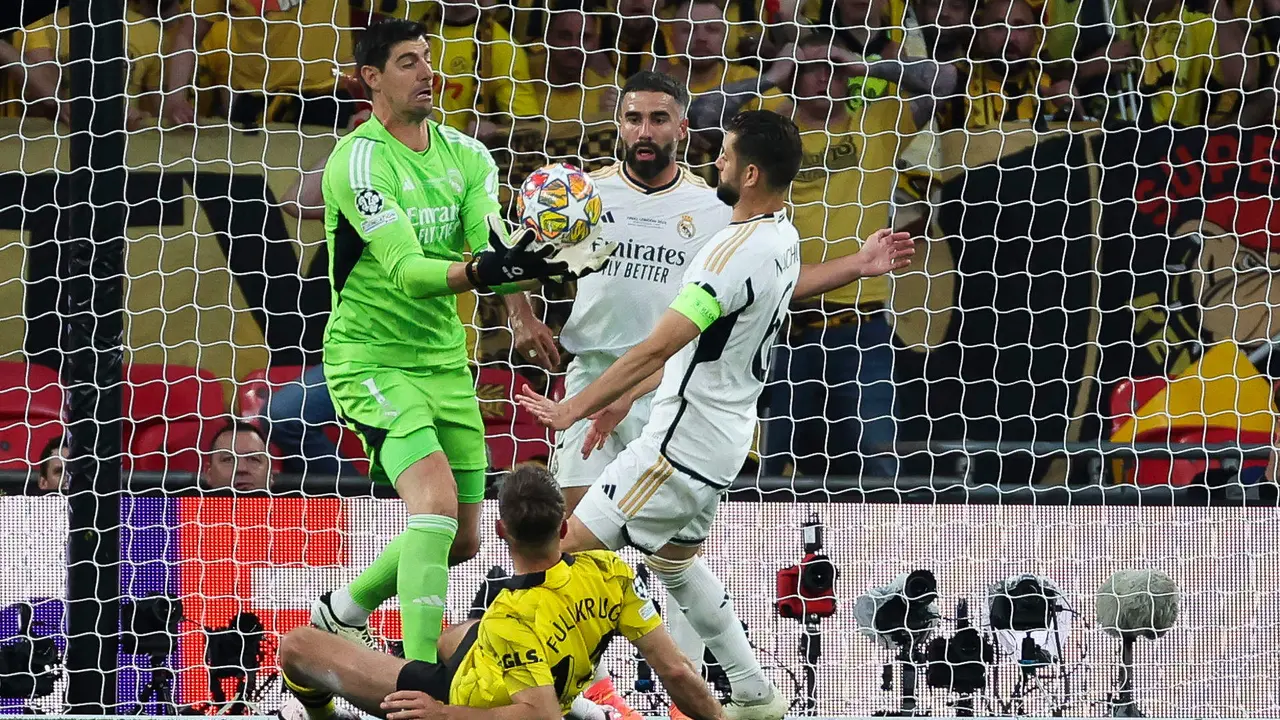 El guardameta belga del Real Madrid, Thibaut Courtois (i), captura el bal&oacute;n ante sus compa&ntilde;eros y el delantero del Borussia Dortmund, Niclas Fulkrug, durante el encuentro correspondiente a la final de la Liga de Campeones que Real Madrid y Borussia Dortmund disputaron en el estadio de Wembley, en Londres. EFE / Kiko Huesca.