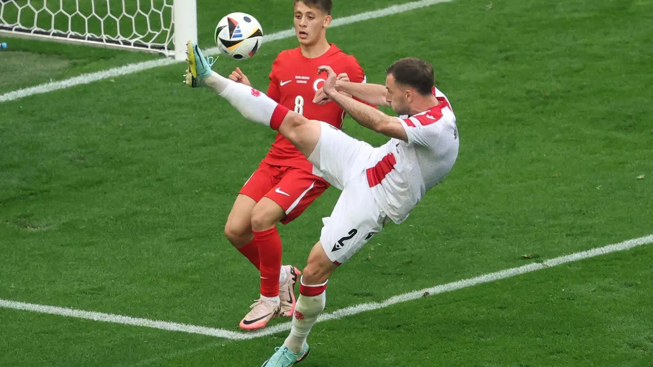 El georgiano Otar Kakabadze (d) despeja el bal&oacute;n ante el joven jugador de Turqu&iacute;a Arda G&uuml;ler en Dortmund, Alemania. EFE/EPA/FRIEDEMANN VOGEL